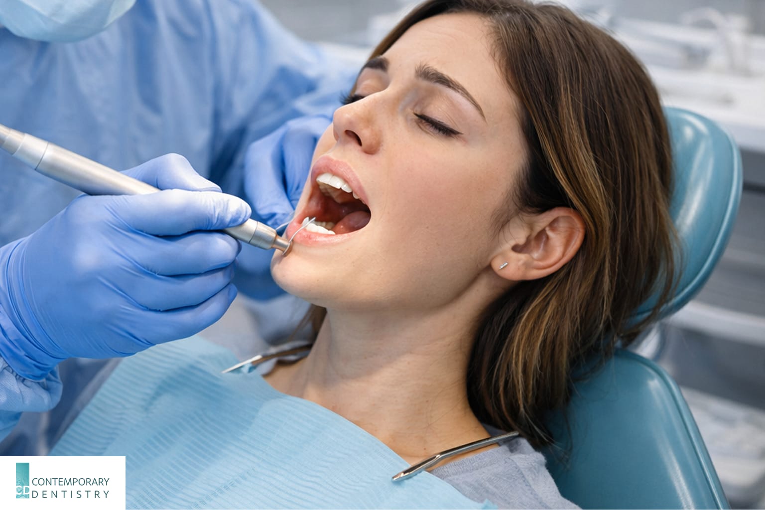 Dentist wearing protective gear using dental tools to perform a procedure on a patient in a dental chair during a clinical treatment.