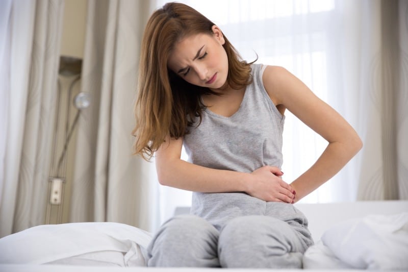 young woman having stomach pain in the morning