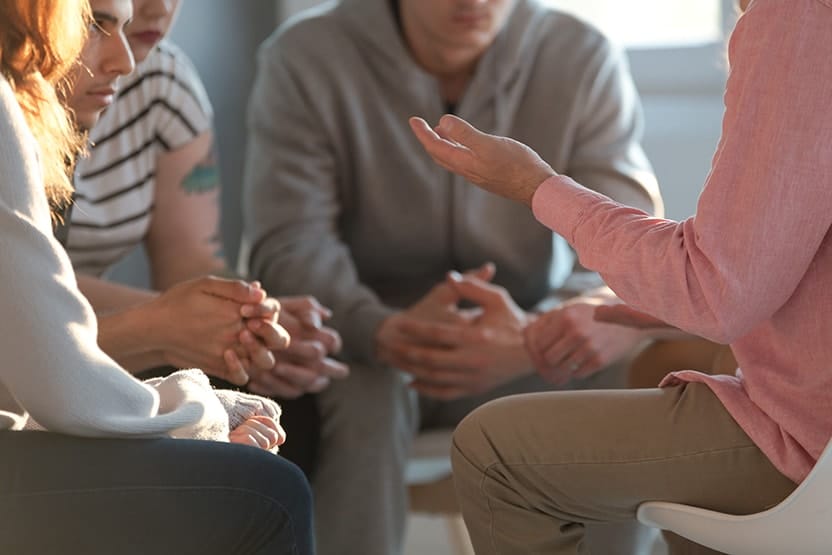 Close-up of a therapist gesticulating while talking to a group of listening drug addicts during an educational self-acceptance and motivation meeting. Recently, a study published by the University of Utah in the Journal of the American Dental Association found that people treated for substance abuse disorders had better outcomes when their oral problems were addressed, too.